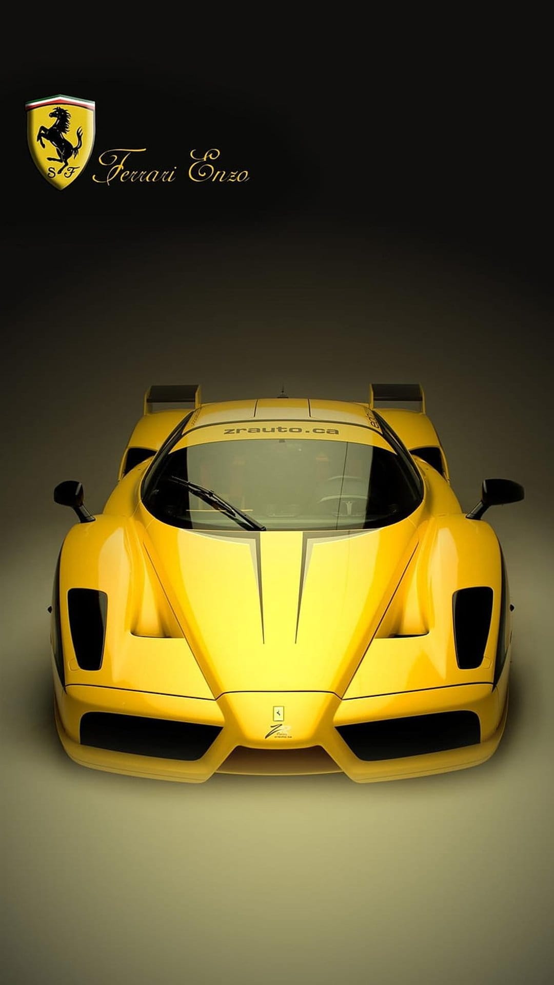Yellow Ferrari Enzo sports car front view featuring the prancing horse emblem and windshield text on the glass.