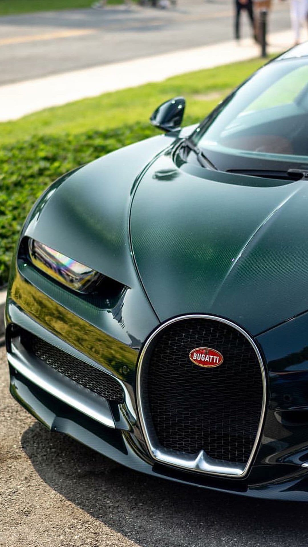Bugatti Chiron headlight and horseshoe grille shown in a close-up detail on a dark green hypercar body.