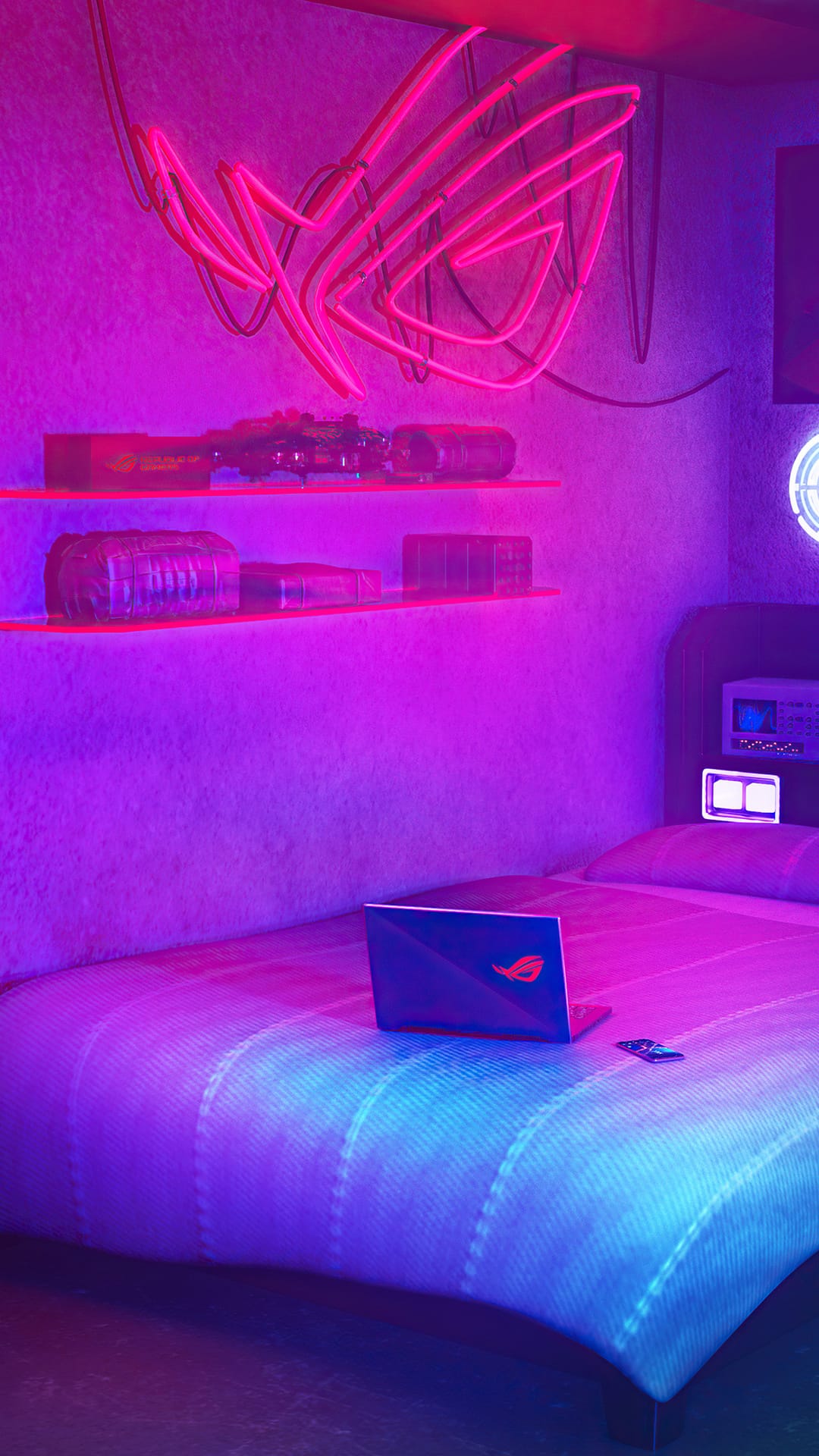 Laptop rests on a bed inside a purple neon gaming room featuring a glowing ROG logo and electronic shelving.