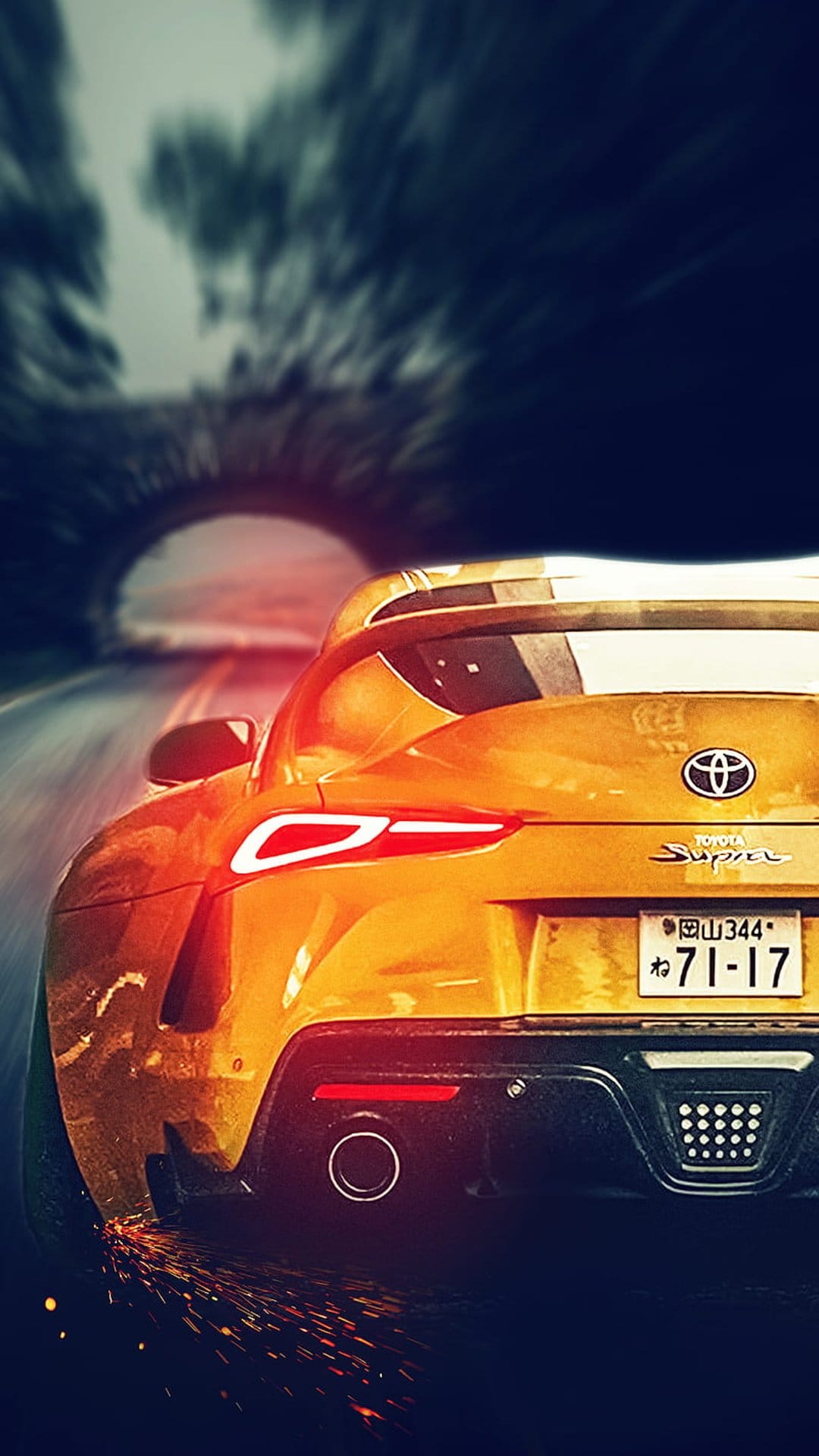 Yellow Toyota Supra drifting under a stone bridge with orange sparks flying from the rear tires at night.