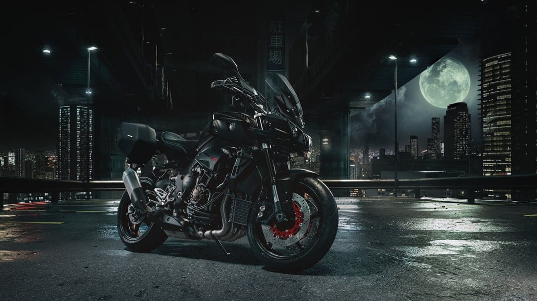 Black Yamaha MT-10 motorcycle on wet asphalt under a full moon in a cinematic nighttime city scene.