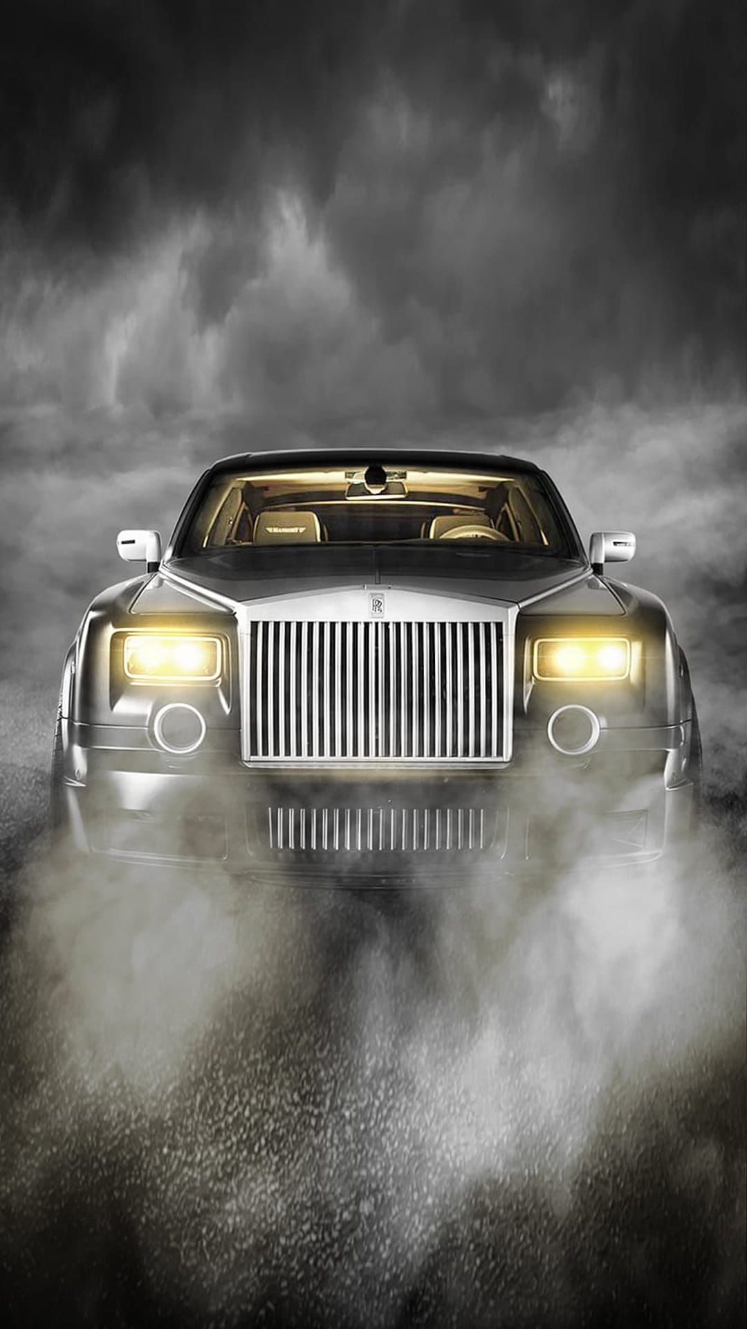 Rolls-Royce Phantom front grille and glowing headlights visible through thick white fog and dark shadows.