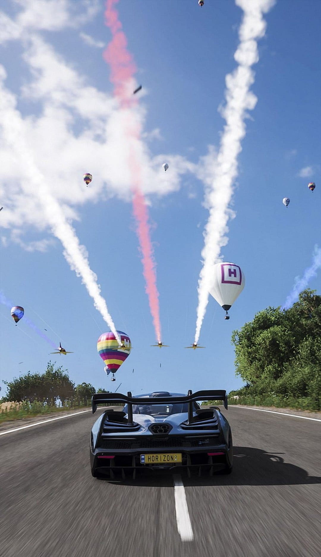 Colorful hot air balloons and jet smoke trails float above a supercar racing through a festive desert landscape.
