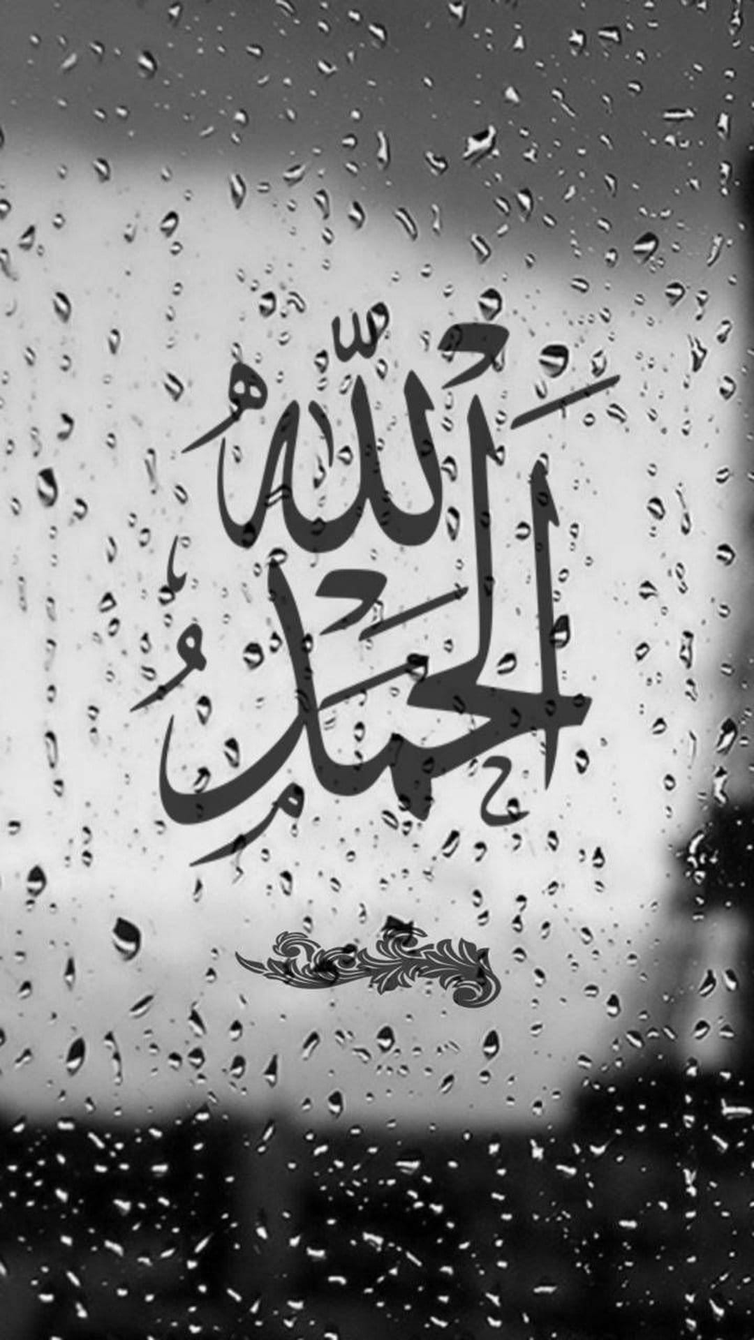 Arabic Alhamdulillah calligraphy centered on a glass window pane covered in realistic raindrops and bokeh.