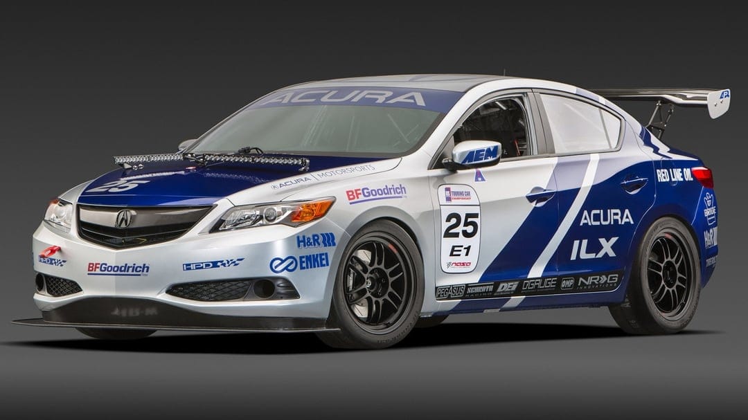 Silver and blue Acura ILX race car with carbon fiber wing and sponsors on a dark studio background.