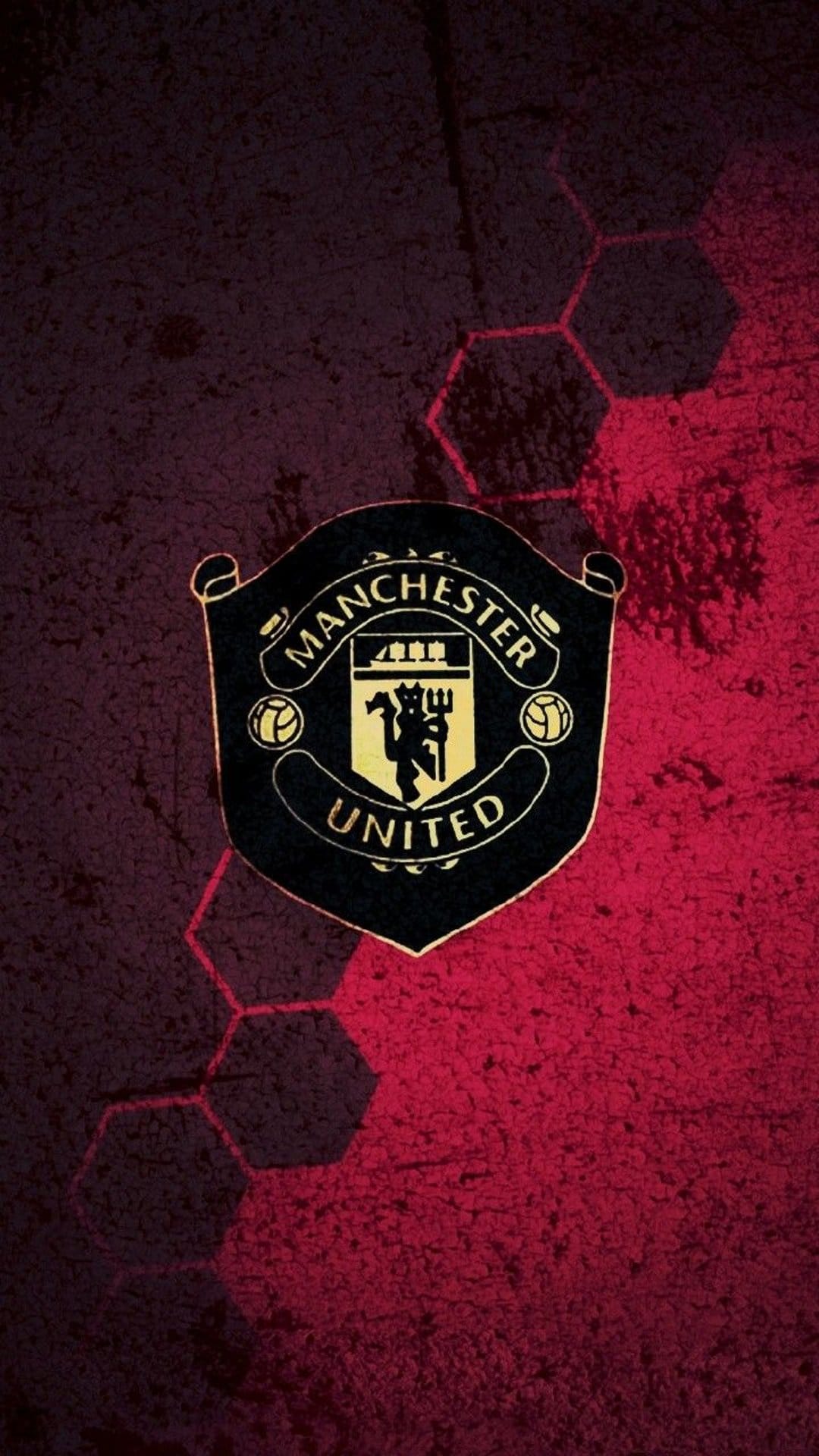 Manchester United crest with gold outlines centered on a dark red background with subtle hexagonal textures.