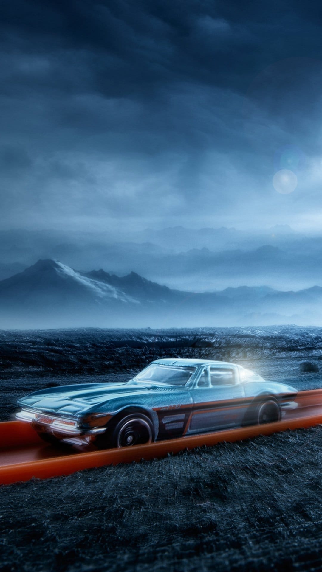 Blue classic toy car racing on an orange track with misty mountains and a dark cloudy sky in the background.