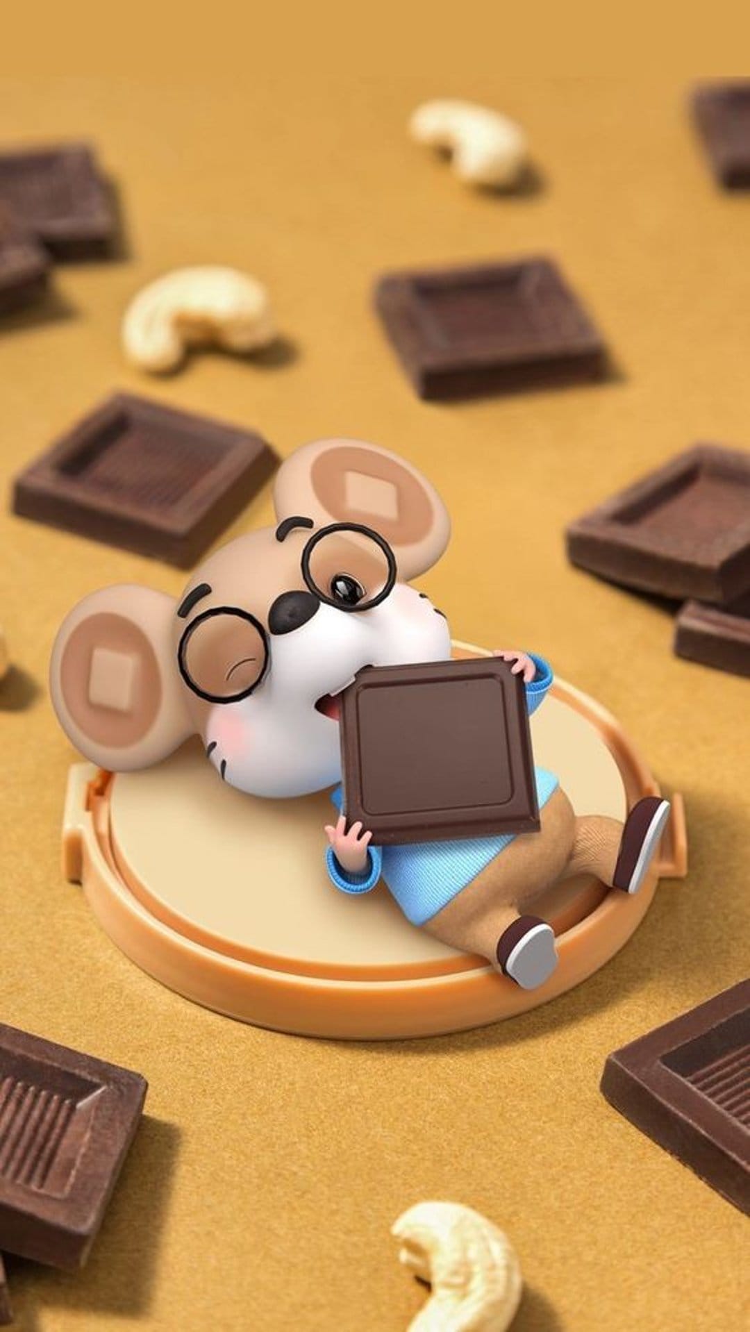 Small mouse with round glasses eating a chocolate chunk surrounded by cashew nuts on a golden brown surface.