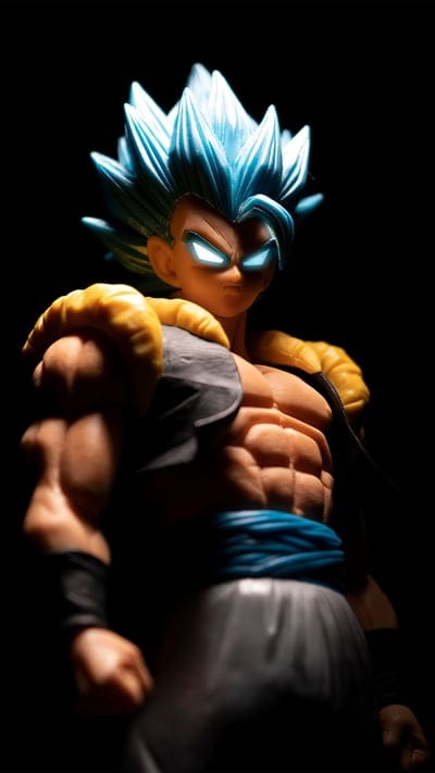 action figure, Gogeta, glowing eyes, Super Saiyan Blue, Dragon Ball, collector's item, anime, powerful, dark background, photography, fusion, DBZ, character, statue, toy, blue hair, intense lighting