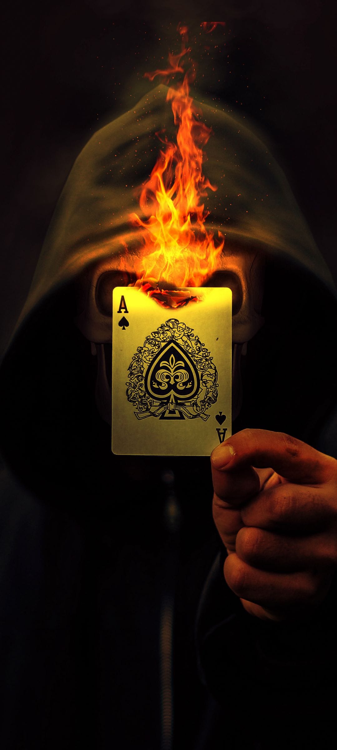 Hooded figure with a face made of fire holds a glowing golden Ace of Spades card against a dark background.