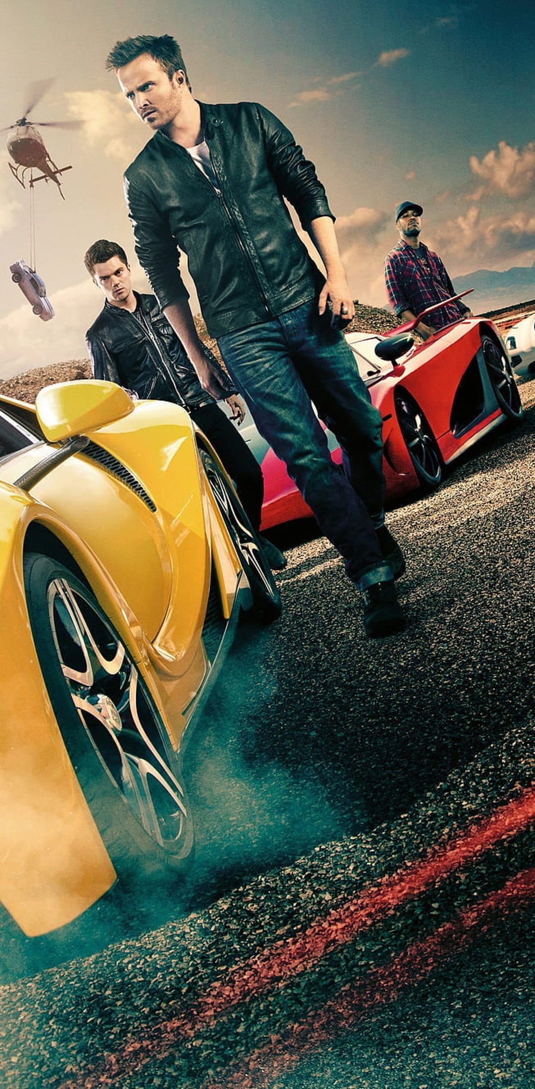 Aaron Paul drives a yellow supercar alongside a red Koenigsegg during a fast-paced street racing movie scene.