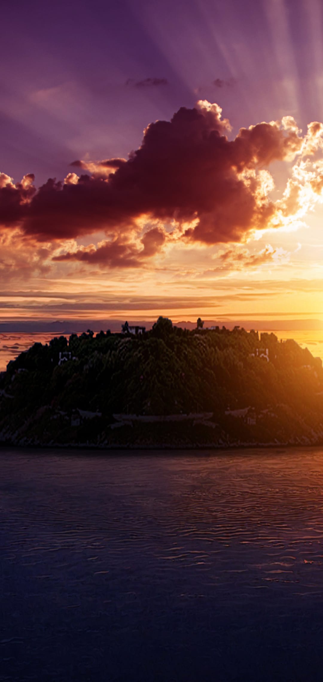Golden sunbeams pierce through heavy purple clouds over a silhouetted island in the middle of a calm ocean.