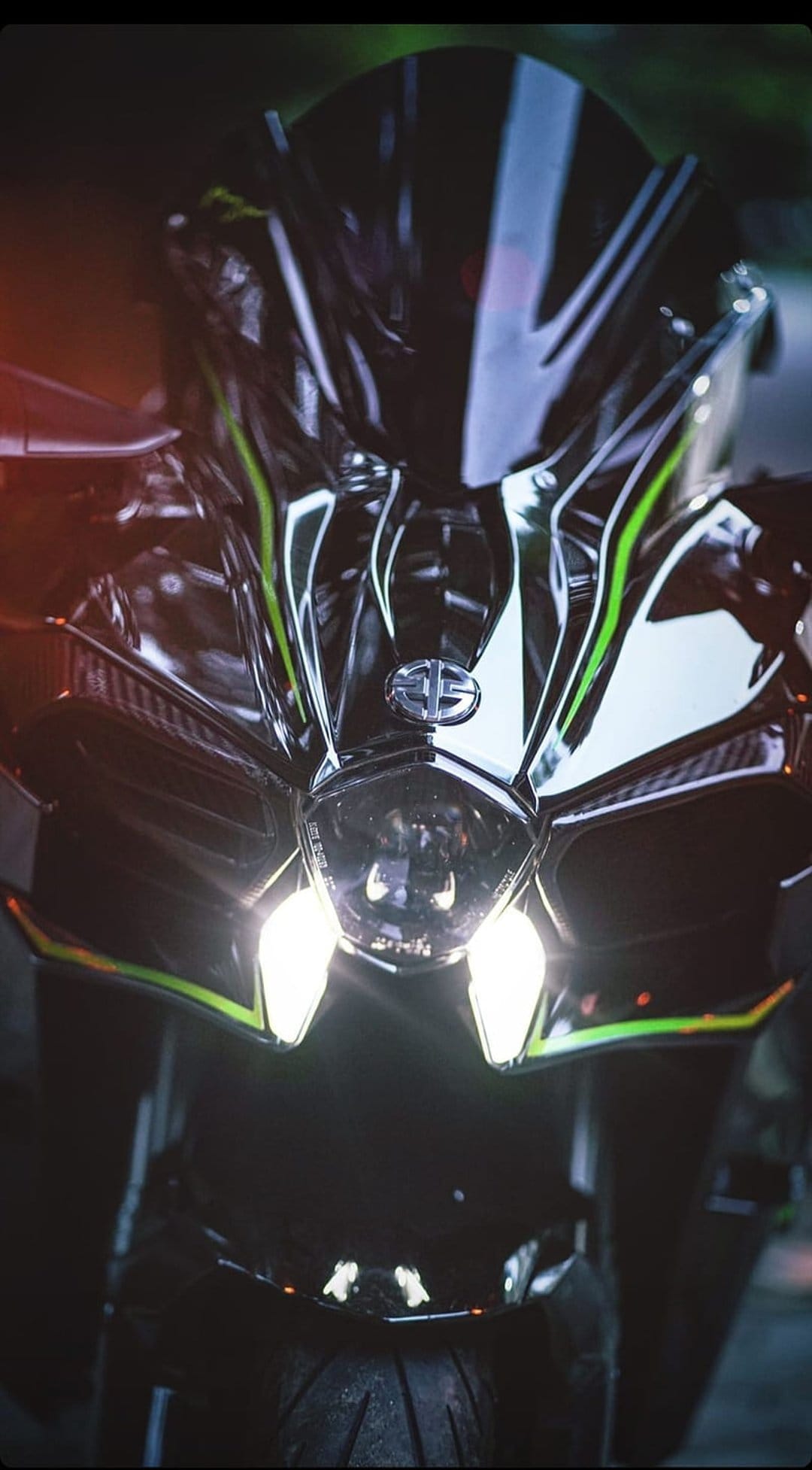 Kawasaki Ninja H2R front fairing with glowing LED headlights and green accents in a dark atmospheric setting.