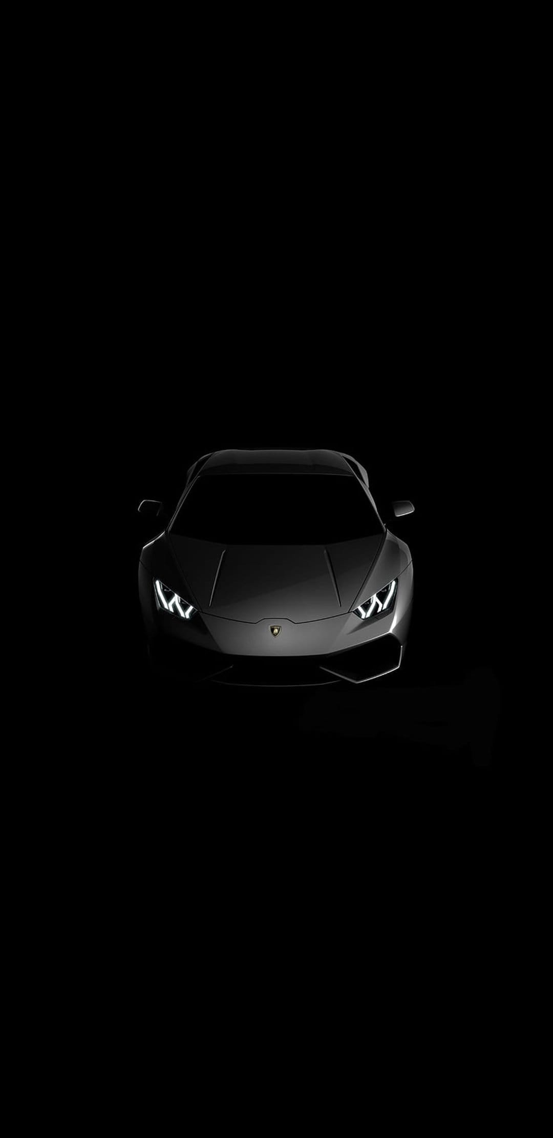 Black Lamborghini supercar with glowing LED headlights and sharp aerodynamic lines against a dark background.