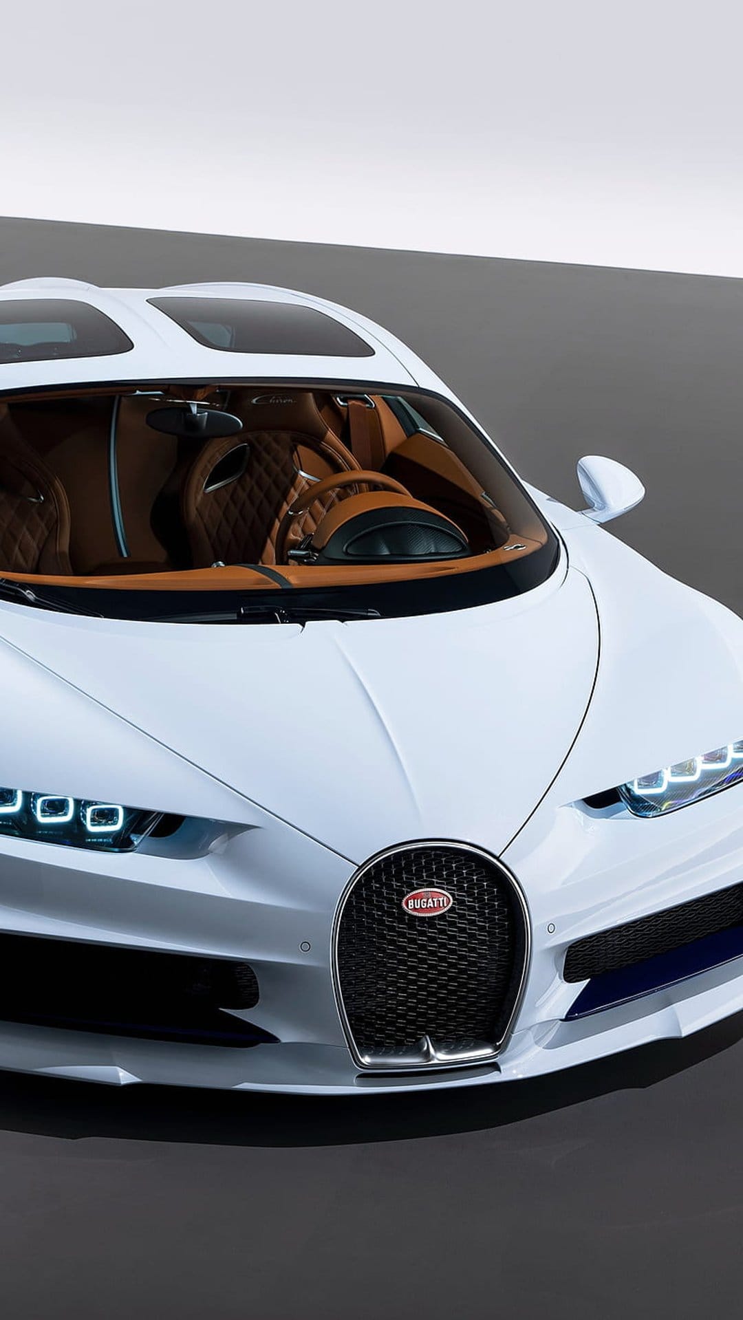 Bugatti Chiron in white with a tan leather interior, featuring a horseshoe grille and sharp LED front headlights.