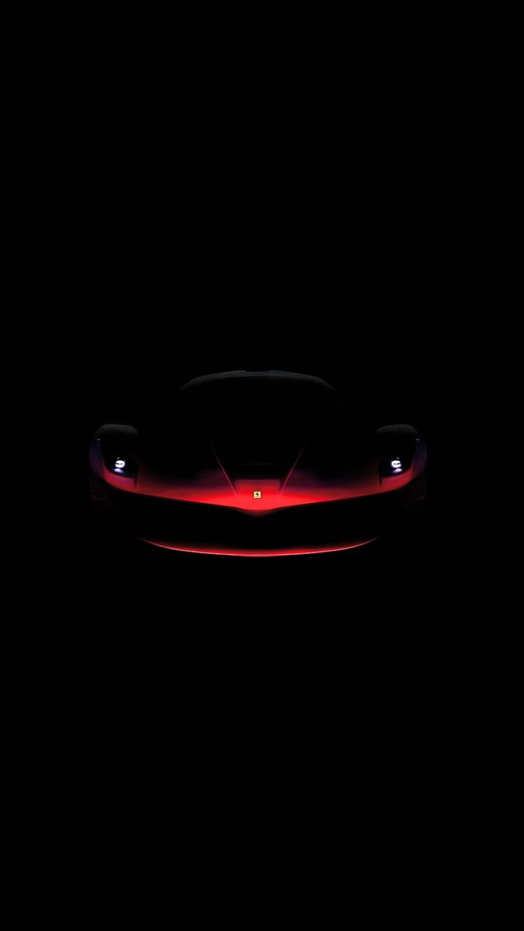 Red Ferrari sports car with glowing headlights and crimson grille illumination against a black background.