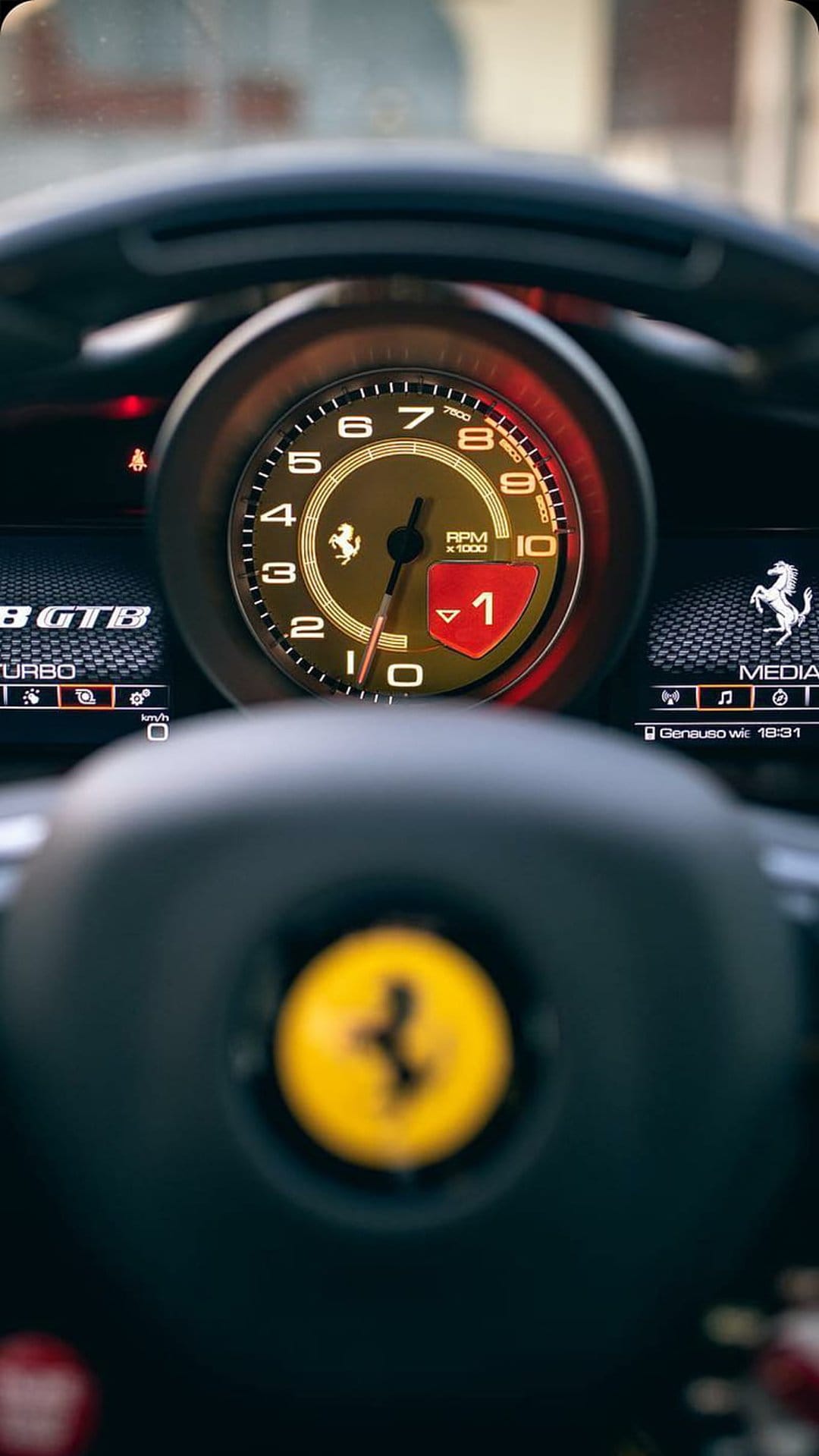 Ferrari digital dashboard displays a red tachometer, gear number one, and turbo boost metrics in a dark cockpit.