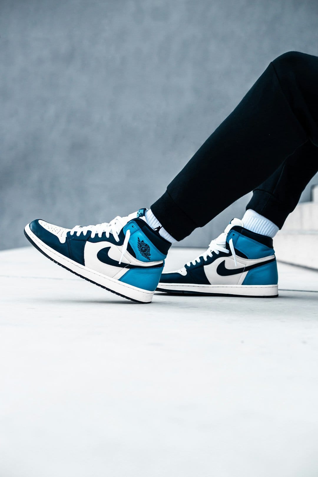 Dark Marina Blue Air Jordan 1 high-top sneakers with white leather accents and blue laces shown in a close-up.