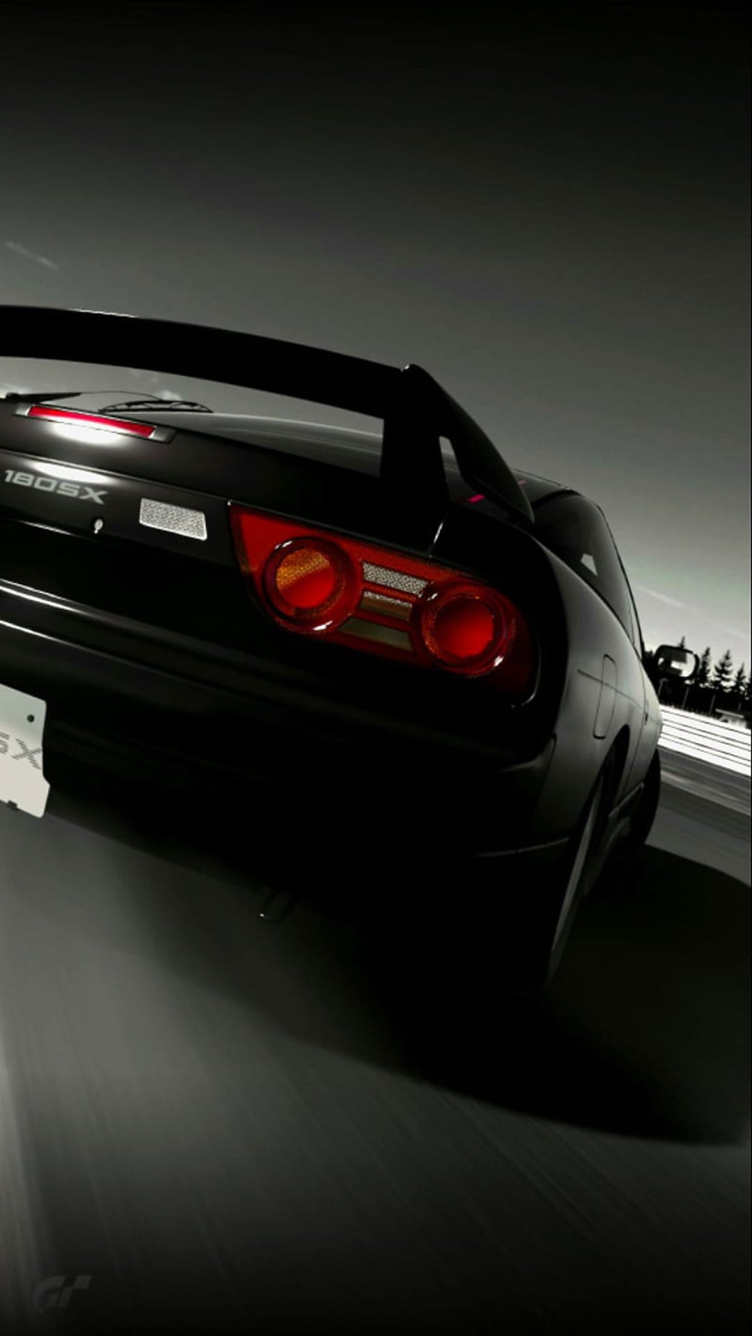 Nissan 180SX rear taillights and bumper visible on a dark road with motion blur in a black and white photograph.