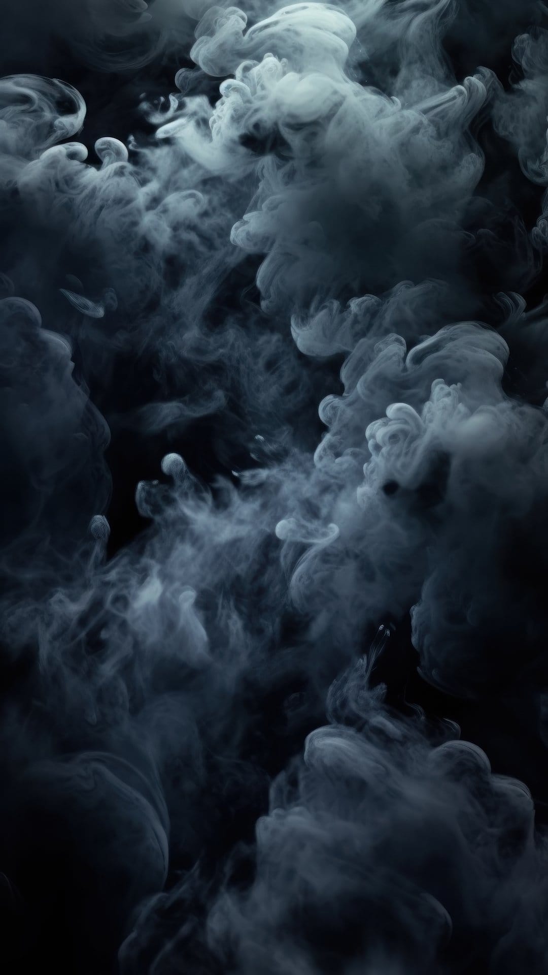 Wispy charcoal smoke plumes swirl in fluid patterns against a solid black background with sharp contrast.