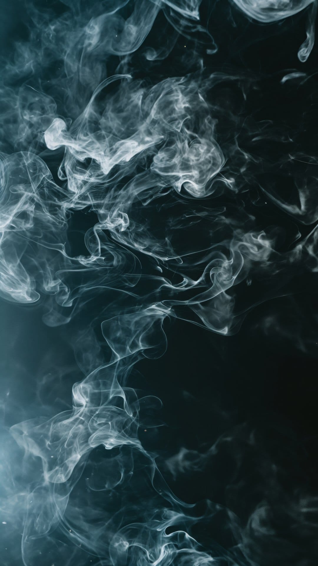 White smoke wisps curl and flow in intricate patterns against a deep black background with soft lighting.