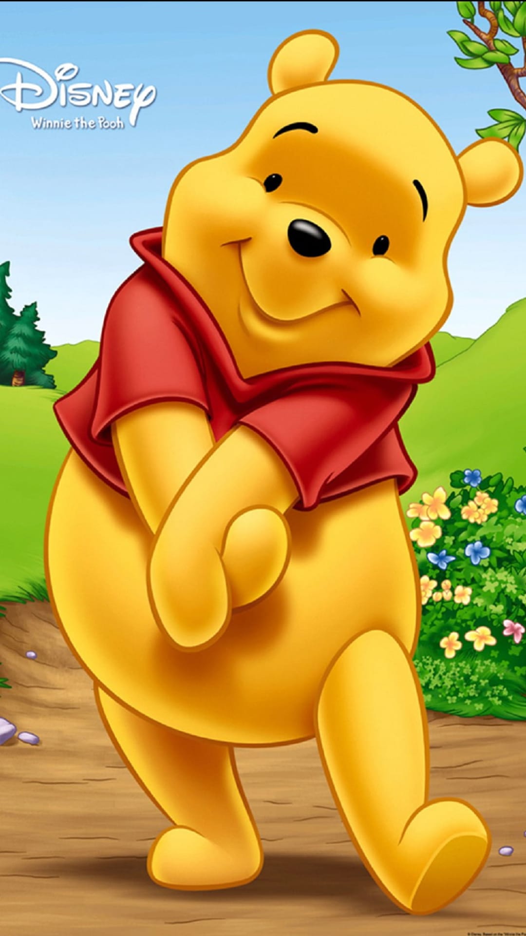 Winnie the Pooh smiles in a green forest with red, blue, and yellow flowers under a sunny woodland canopy.
