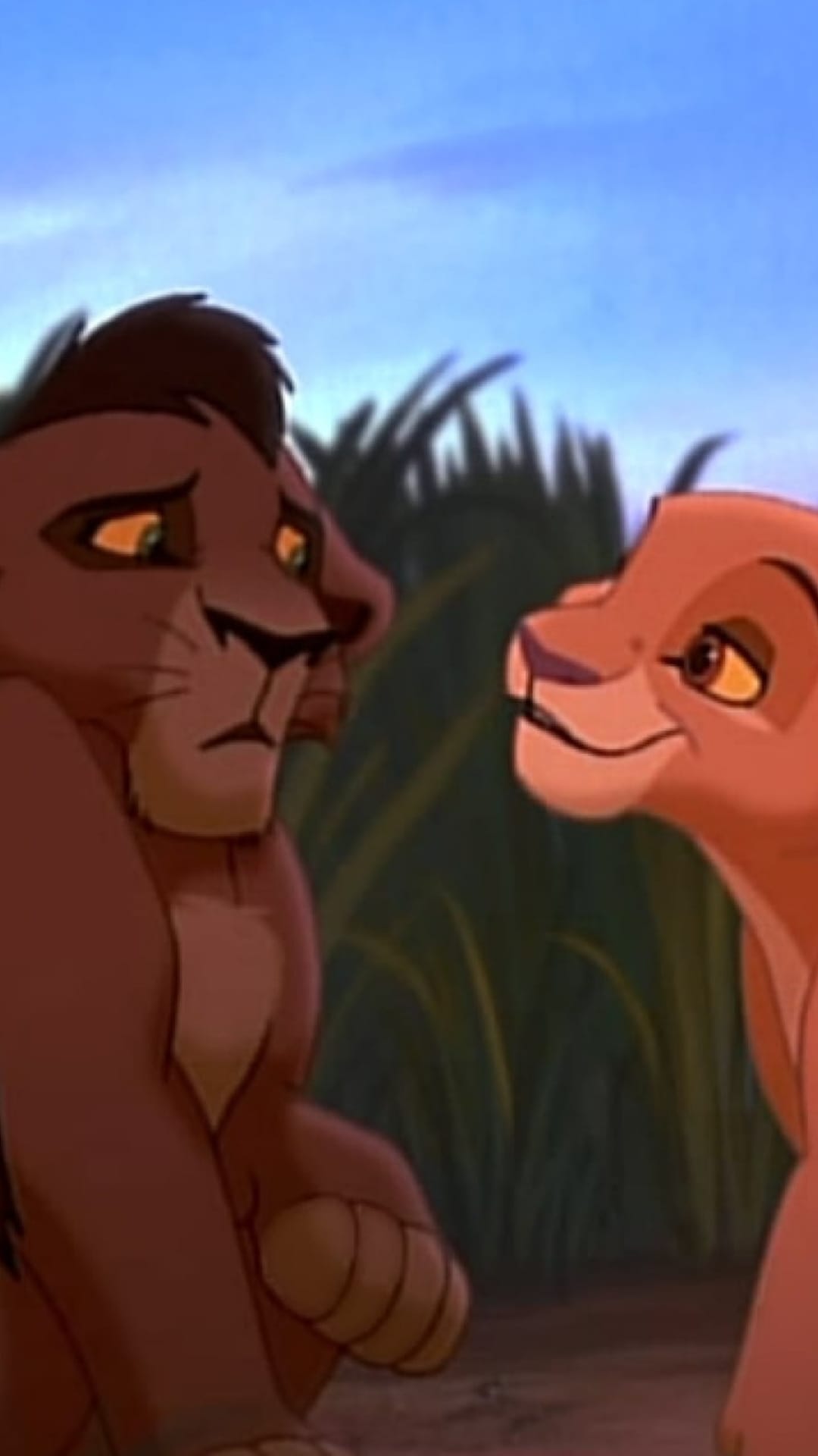 Two animated lions stand in tall grass; one dark-maned lion looks down sadly at a smiling lighter-maned lion.