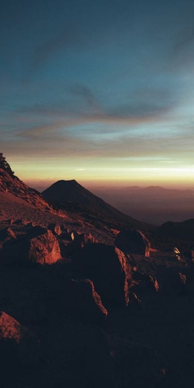 Mountain sunrise, Rugged landscape, Golden hour, Dawn, Scenic, Mountain peaks, Nature, Atmospheric, Outdoor, Vastness, Tranquil, Beautiful, Rocky terrain, Horizon, Sky colors, Majestic, Wilderness, Early morning, Natural light, Landscape photography