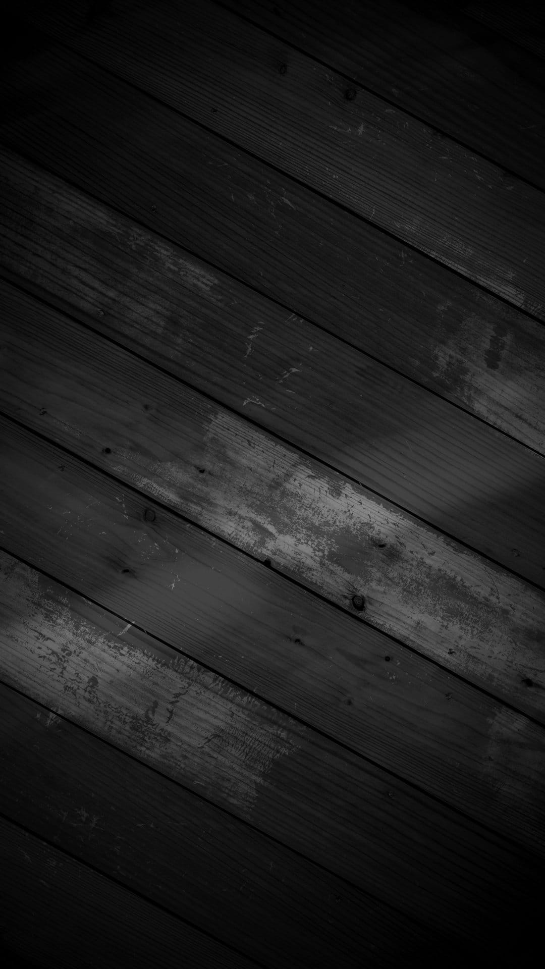 Dark wooden planks arranged in a diagonal pattern featuring natural grain, knots, and weathered surface textures.