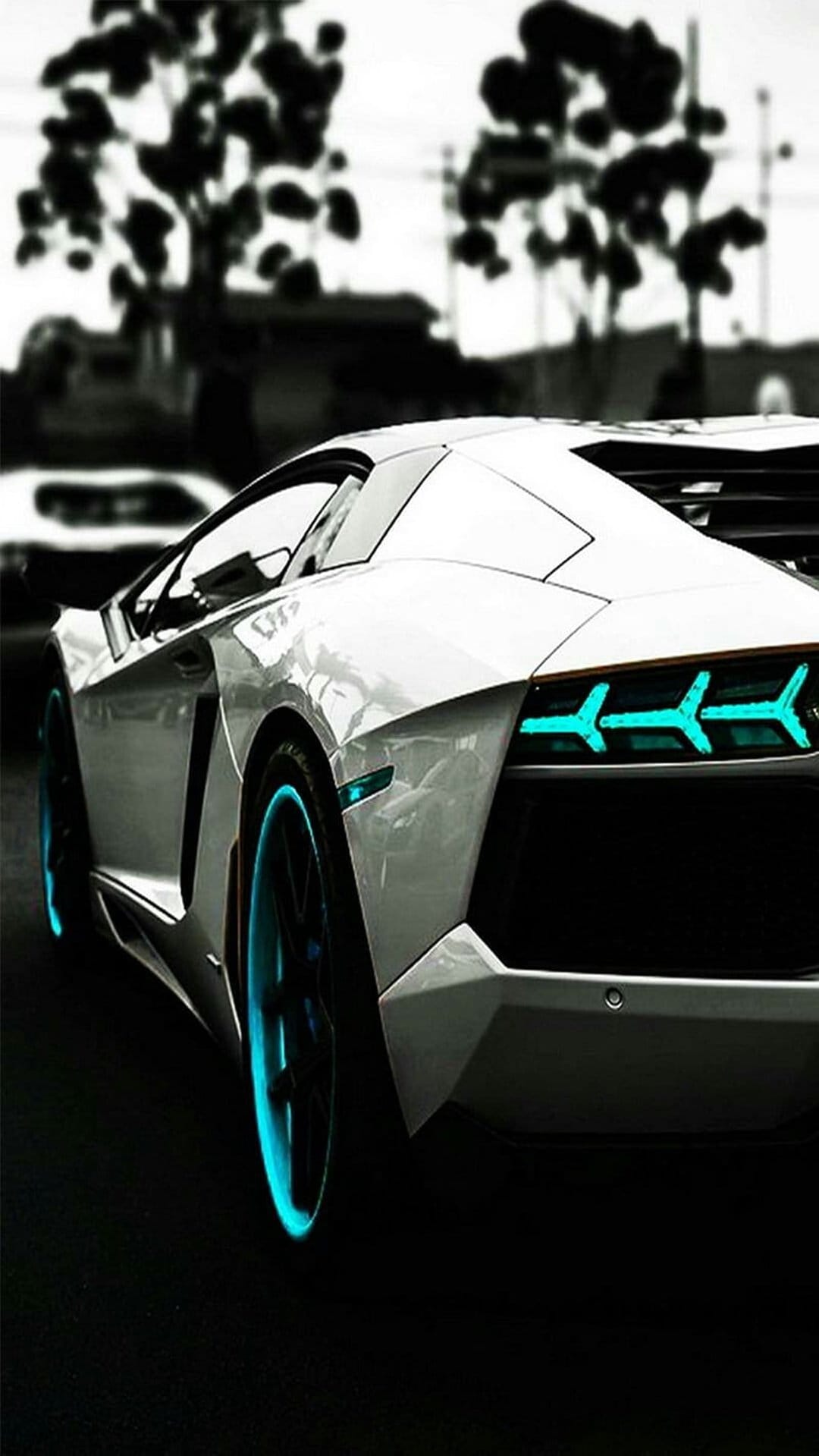 White Lamborghini Aventador showing glowing blue taillights and wheel rims from a low-angle rear perspective.