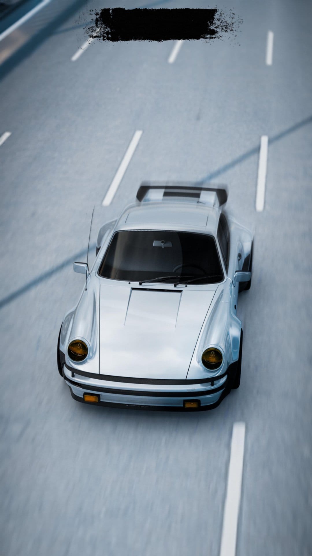 Silver Porsche 911 with a large rear spoiler racing on a blurred asphalt road from an overhead perspective.