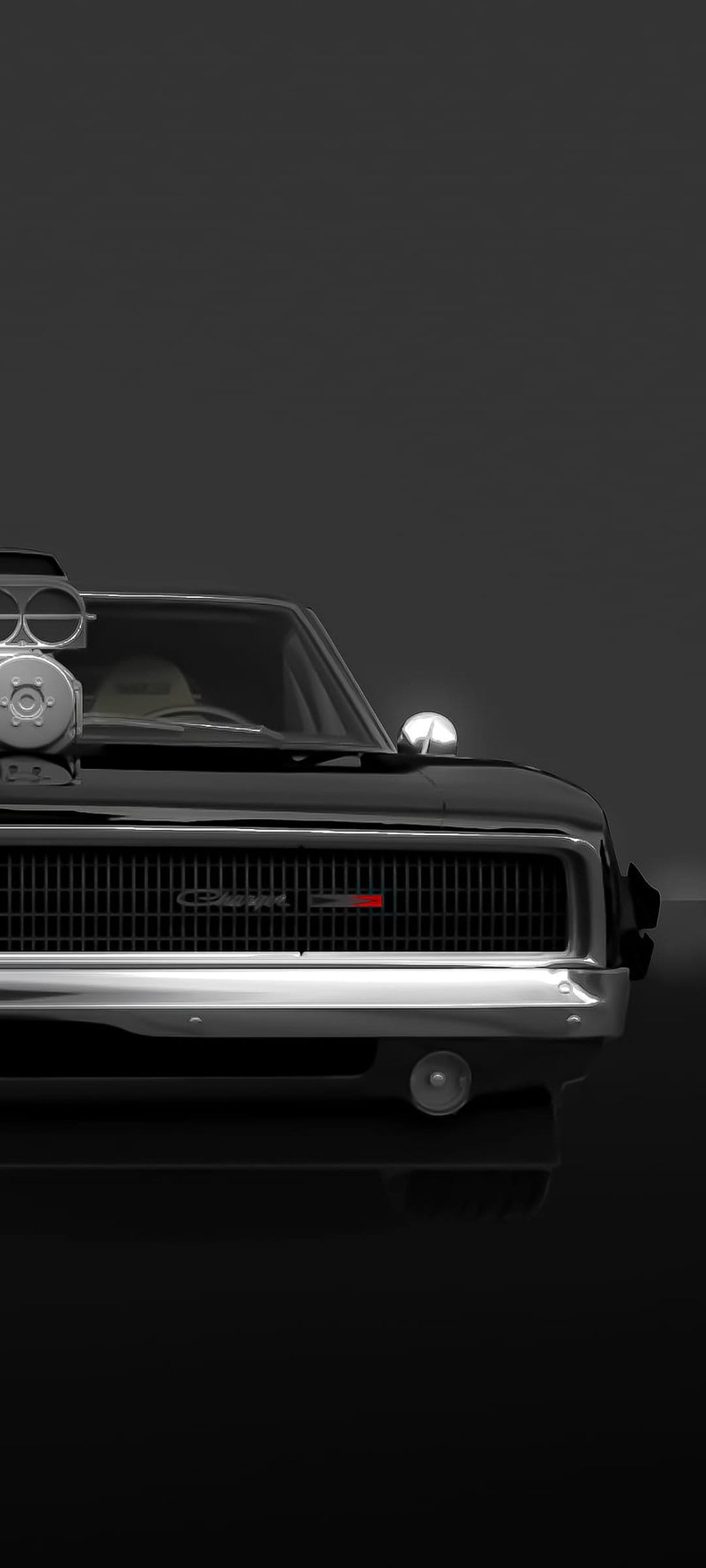 Classic Dodge Charger with a chrome supercharger blower and front grille under dramatic low-key lighting.