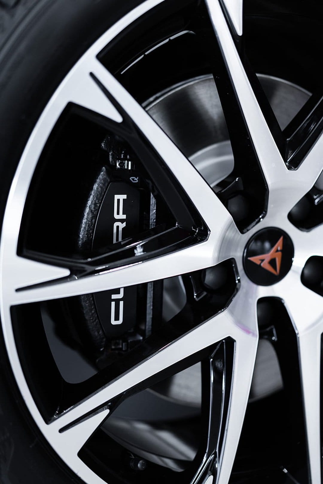 Cupra brake caliper and alloy wheel spokes with a copper center logo in a close-up automotive photography shot.