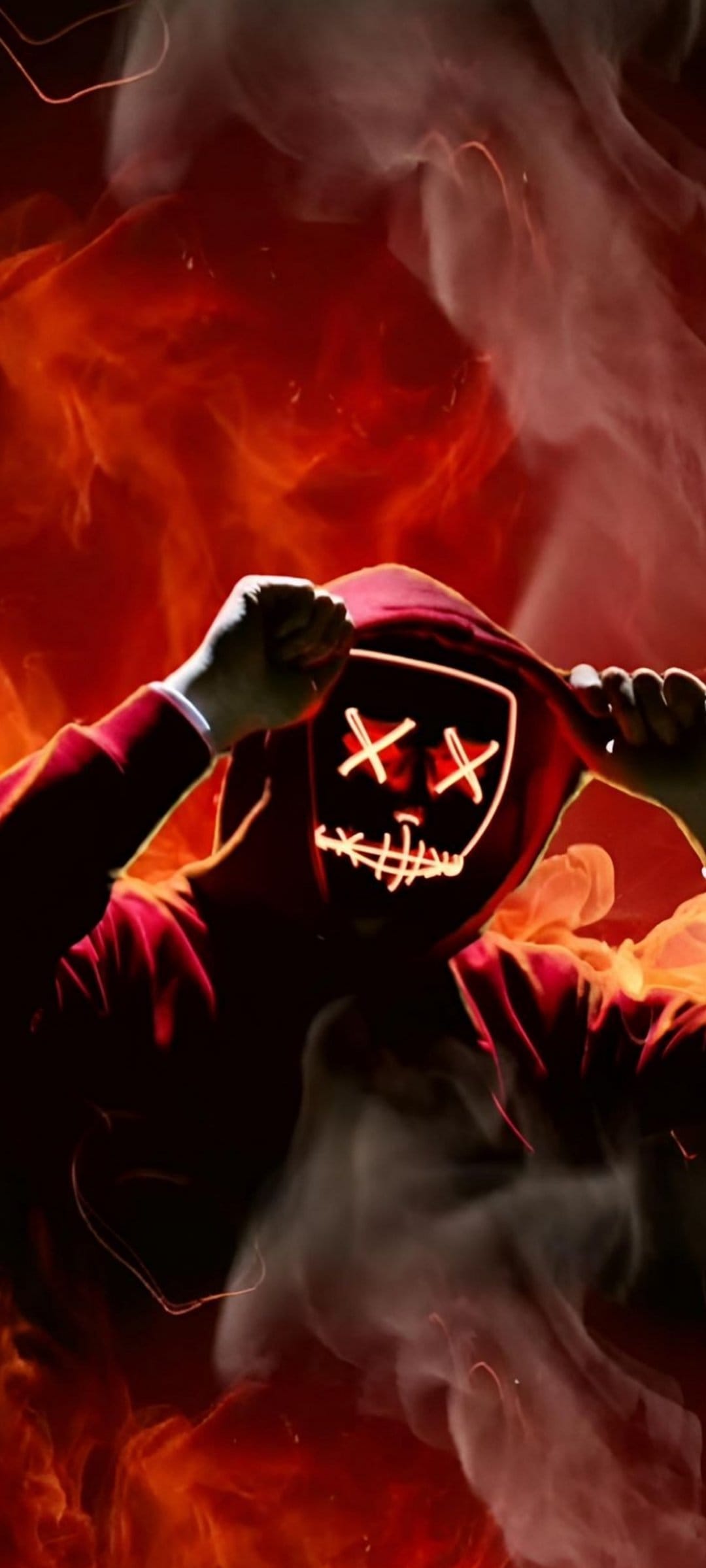 Masked figure with glowing X eyes and a red hoodie stands centered within intense red flames and white smoke.