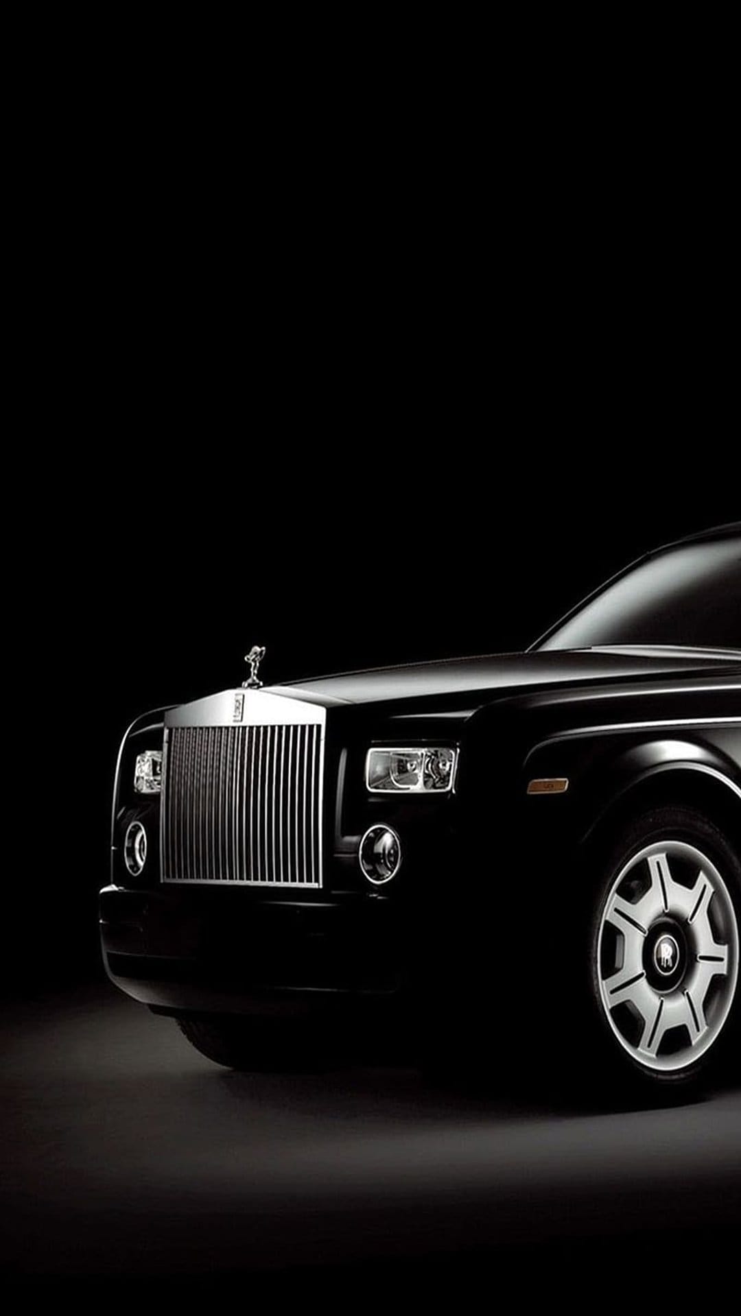 Rolls-Royce Phantom front grille and Spirit of Ecstasy ornament centered against a dark, shadowy background.