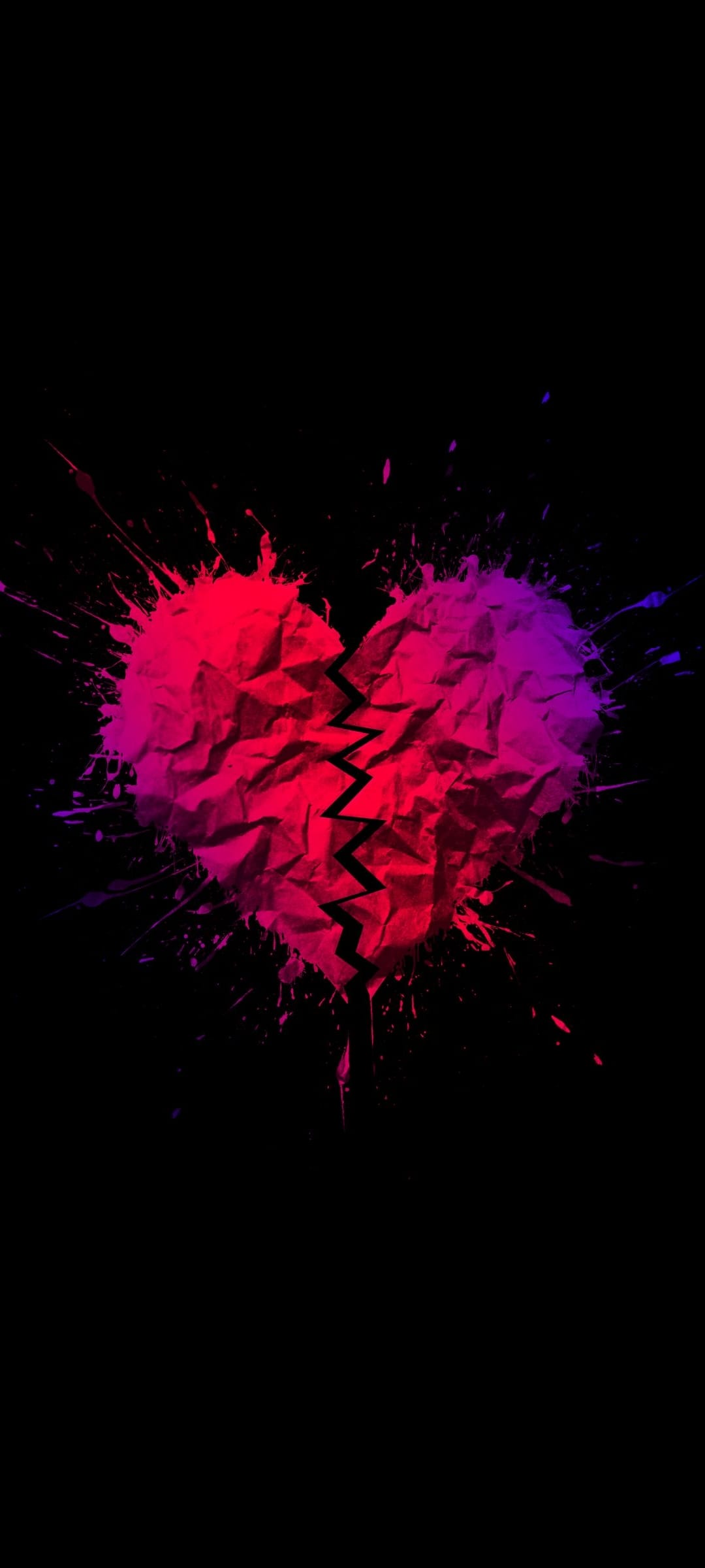 Broken heart with crumpled paper texture surrounded by red and purple paint splatters on a black backdrop.