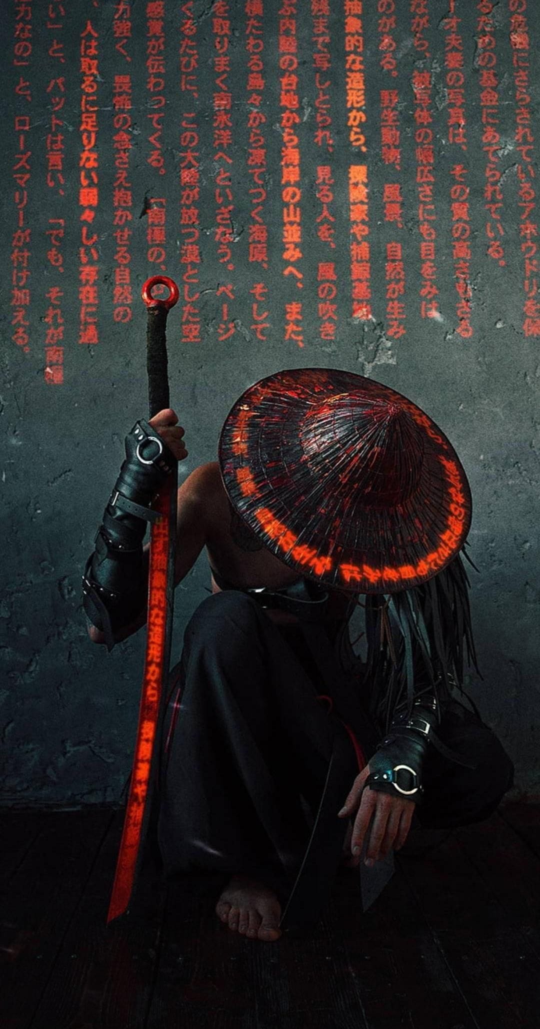 Samurai warrior in a conical hat hunched over a glowing red sword against a dark, gritty wooden background.