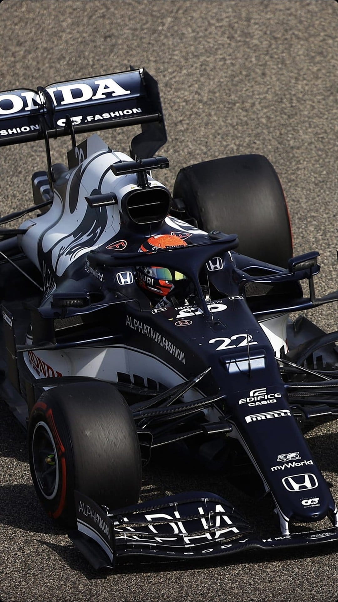 AlphaTauri F1 car with racing driver number 22 in the cockpit on a paved track with Honda branding visible.