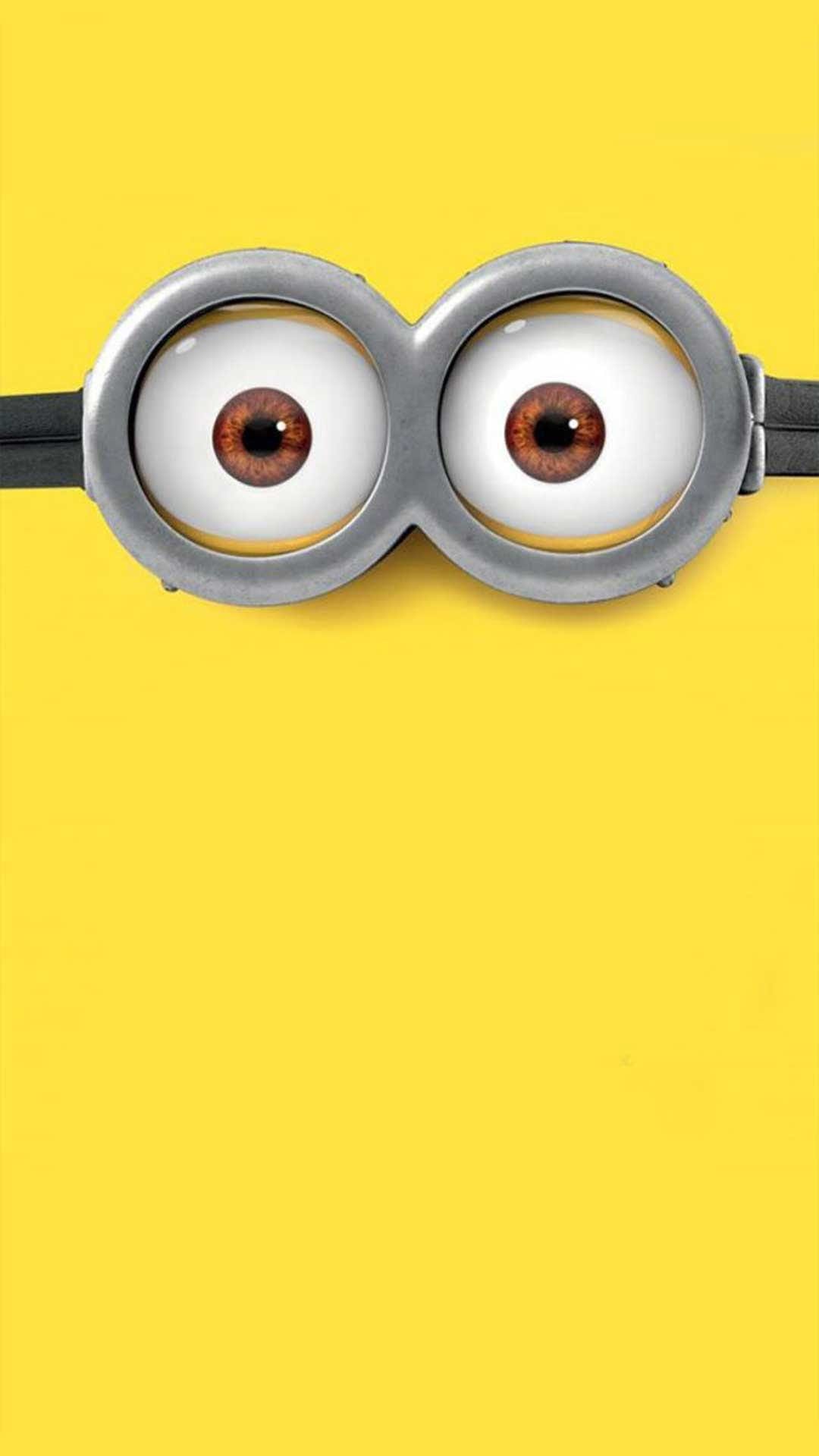 Minion goggles with silver metallic frames and brown eyes centered on a bright yellow vertical background.