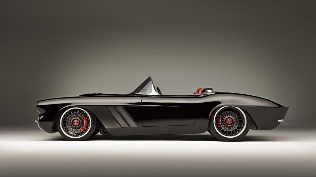Black custom vintage convertible car with red brake calipers and carbon fiber vents on a grey studio background.
