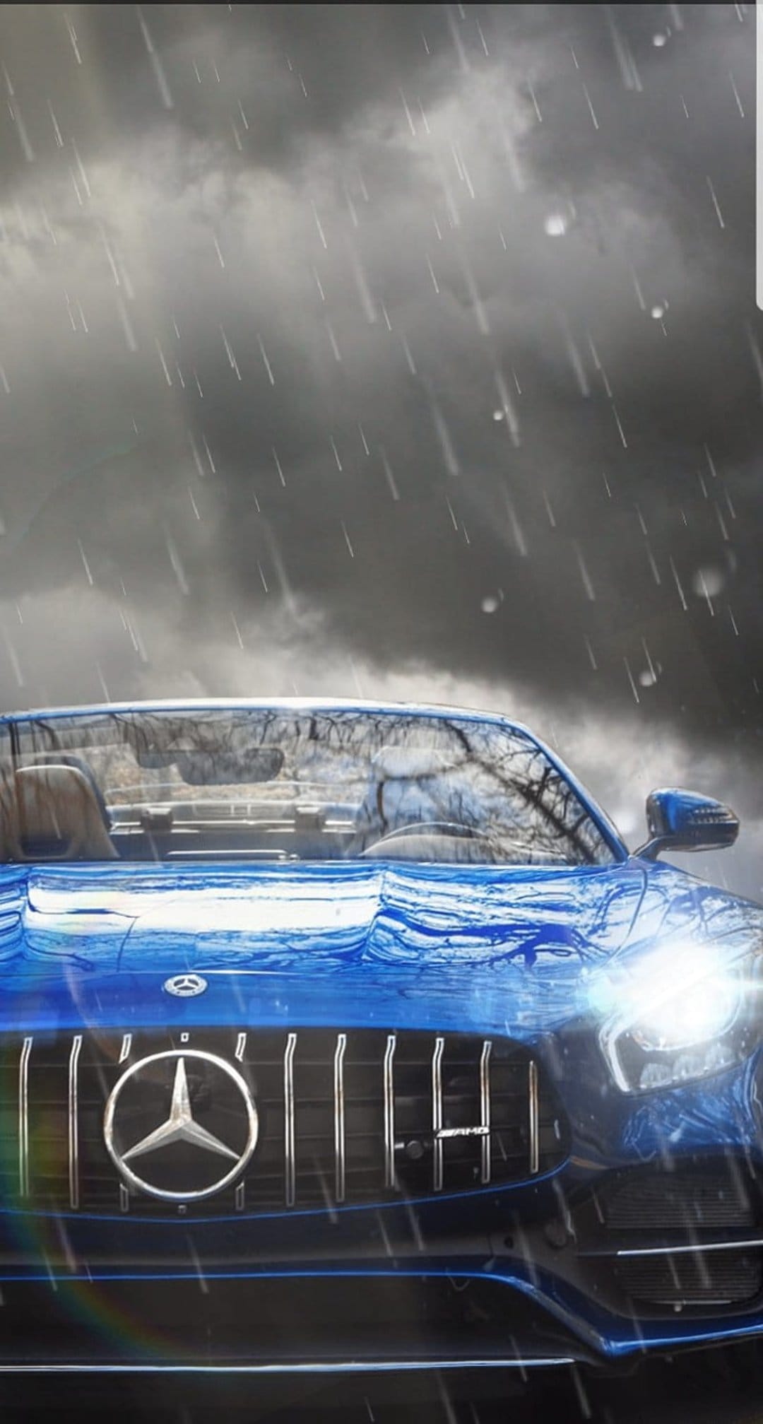 Blue Mercedes convertible with glowing headlights on a wet road during a heavy rainstorm under dark clouds.