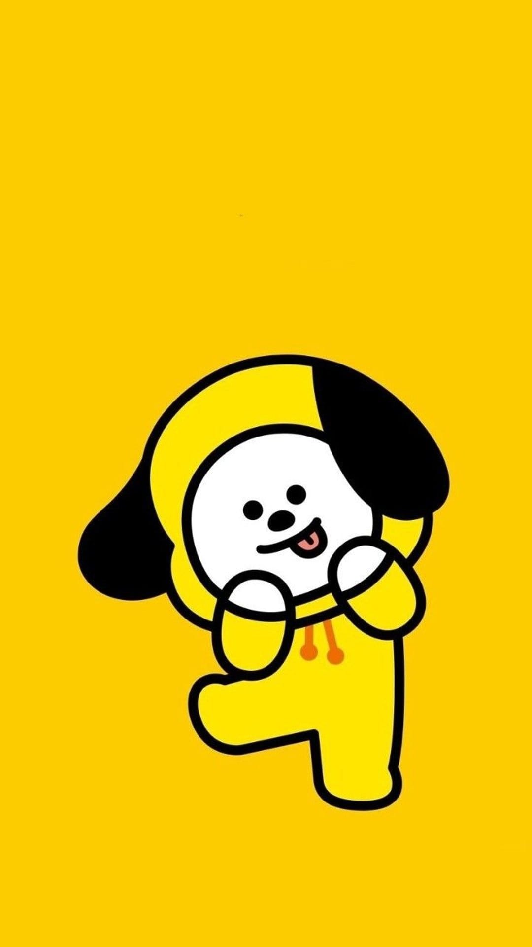 Chimmy the BT21 puppy wearing a yellow hoodie and sticking its tongue out against a solid yellow backdrop.