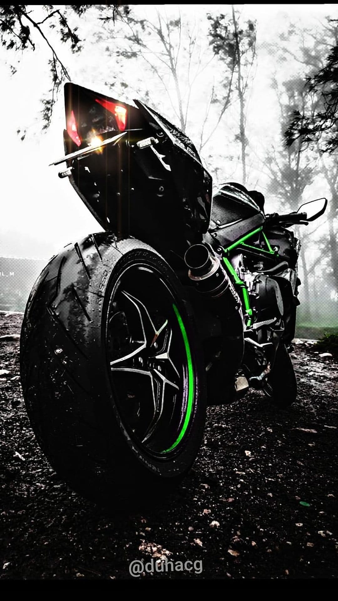 Kawasaki Ninja H2R motorcycle on wet pavement with lime green accents and a misty forest in the background.