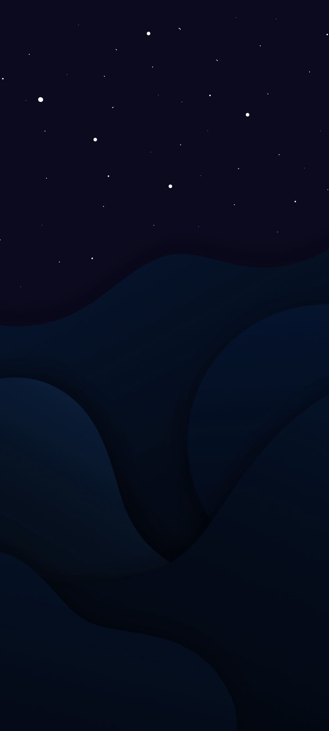 Layered dark blue mountain silhouettes rest under a vast night sky filled with small, scattered white stars.