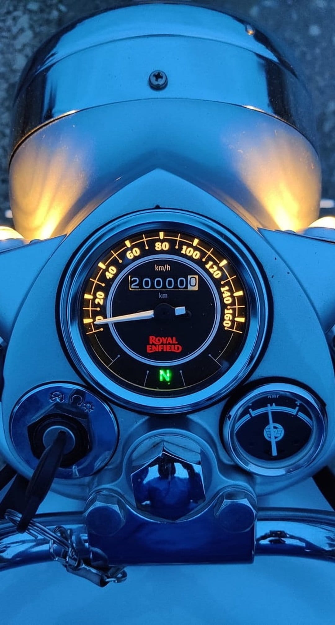 Royal Enfield motorcycle odometer showing 200,000 kilometers with glowing yellow numbers and a green neutral light.