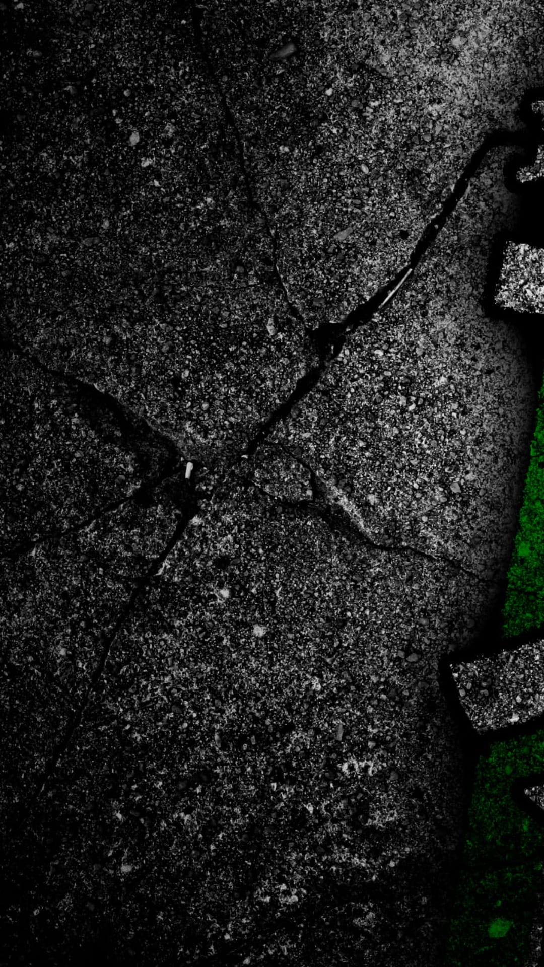 Rough dark concrete texture features deep jagged cracks filled with luminous neon green pigment and shadows.