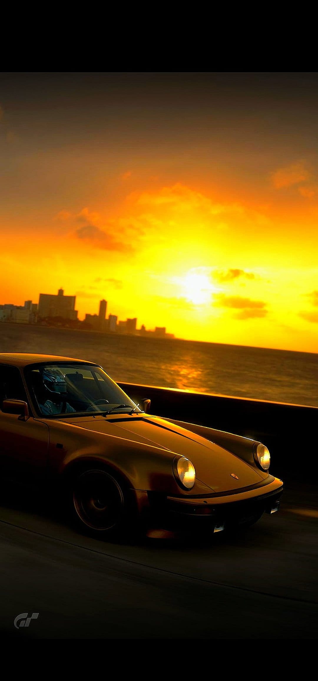 Golden Porsche 911 parked on a coastal road in Havana with a vibrant tropical sunset over the ocean horizon.