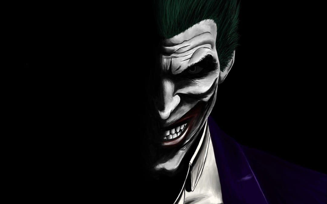 Joker with green hair and a sharp-toothed grin emerges from heavy shadows with glowing, intense eyes.