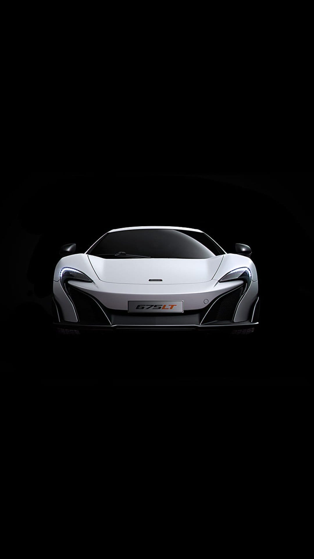 White McLaren 675LT supercar with aggressive aerodynamic vents and a 675LT badge centered on a dark background.