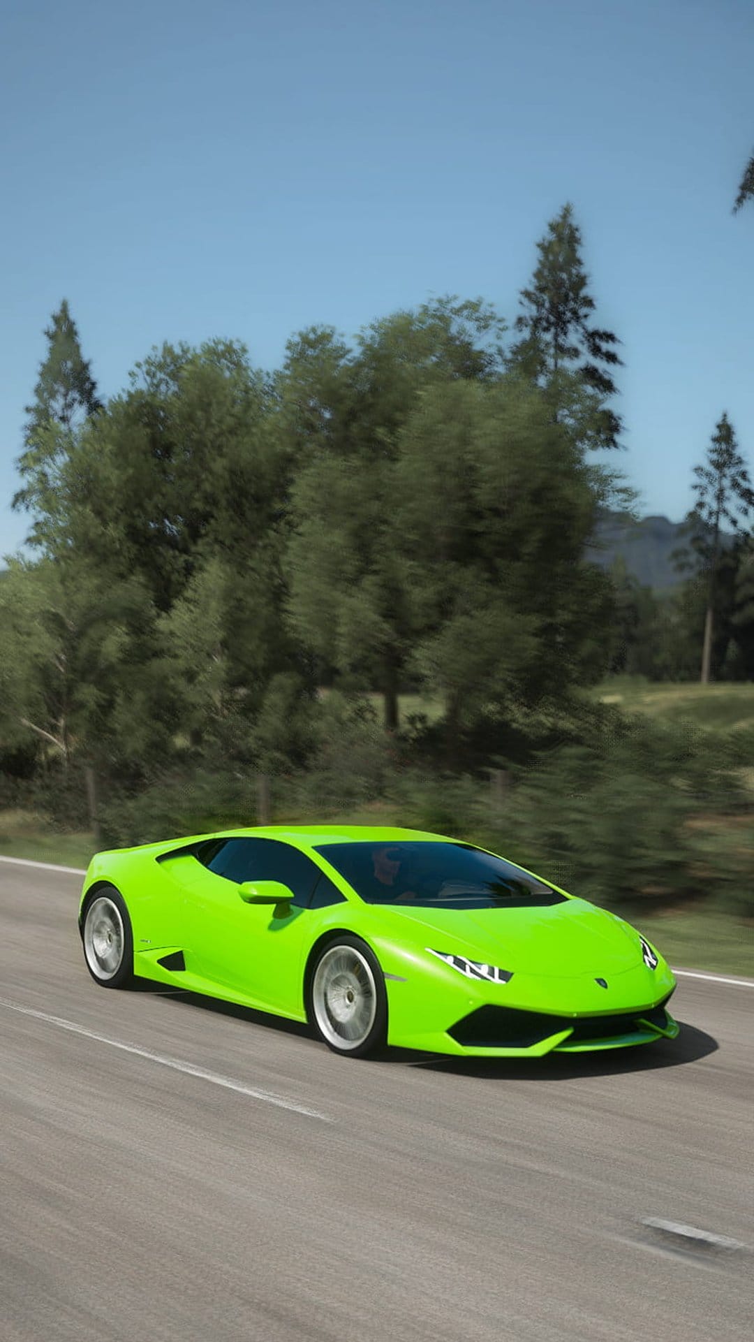 Lime green Lamborghini Huracan accelerating on a road lined with green trees under a bright blue summer sky.